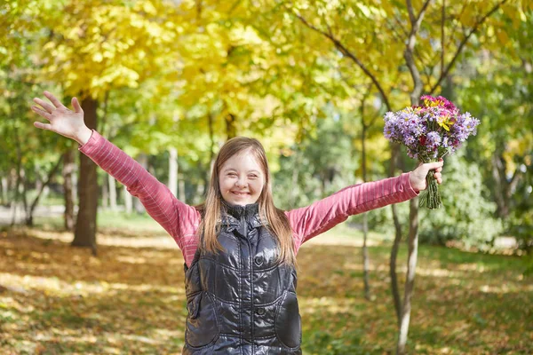 Chica con síndrome de Down en el parque de otoño . — Foto de Stock