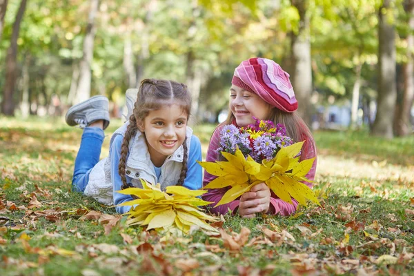 Menina com síndrome de Down e menina no parque de outono . — Fotografia de Stock