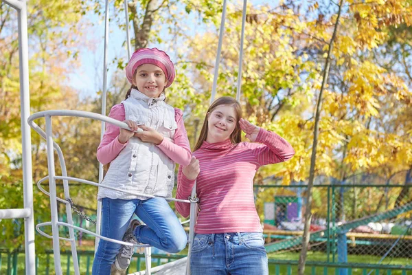 Girl with Down syndrome and little girl in autumn park. — Stock Photo, Image