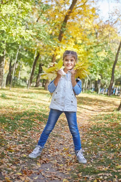 Счастливая девочка в осеннем парке — стоковое фото