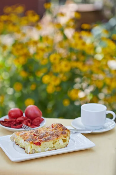 Caserolă, roșii, cafea pe o masă mică în grădină — Fotografie, imagine de stoc