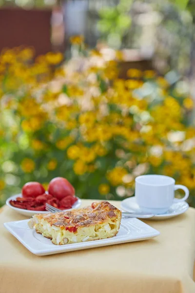 Caserolă, roșii, cafea pe o masă mică în grădină — Fotografie, imagine de stoc