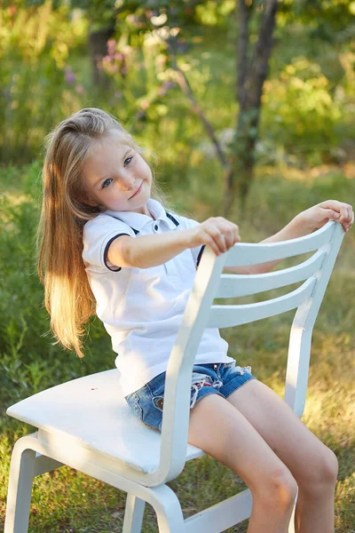 Menina Encantadora Sentada Uma Cadeira Branca Jardim Verão — Fotografia de Stock