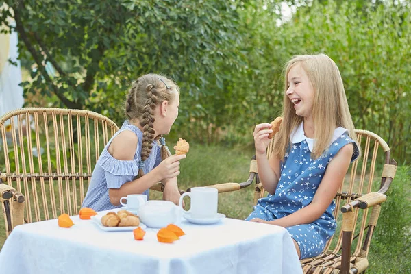 二人の小さな女の子が夏の庭でお茶を飲んで アームチェアに座っています お茶を飲む 楽しい — ストック写真