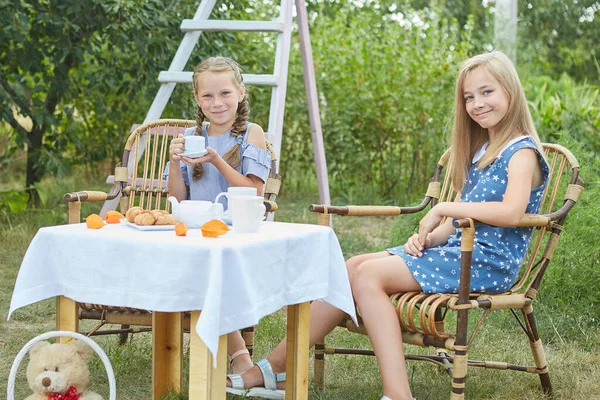 Två Små Flickor Sitter Fåtöljer Och Dricker Sommarträdgården Dricka Kul — Stockfoto