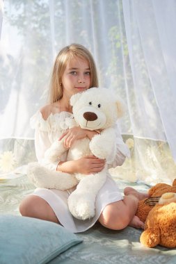 Oyuncak beyaz şifonlu çadırda küçük bir kız. Çocukluk, şefkat, güzellik.