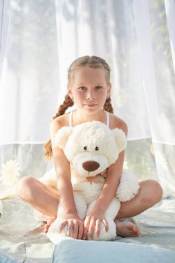 Oyuncak beyaz şifonlu çadırda küçük bir kız. Çocukluk, şefkat, güzellik.