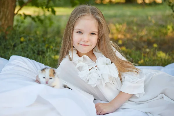 Mała Dziewczynka Leży Łóżku Letnim Ogrodzie Kotkiem — Zdjęcie stockowe