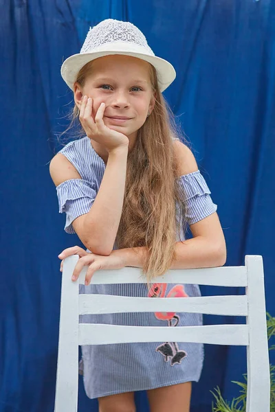 帽子を被った少女は外の青い背景で — ストック写真