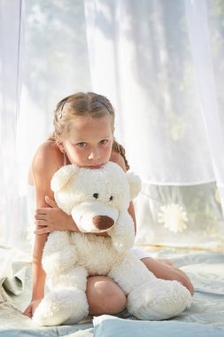 Oyuncak beyaz şifonlu çadırda küçük bir kız. Çocukluk, şefkat, güzellik.