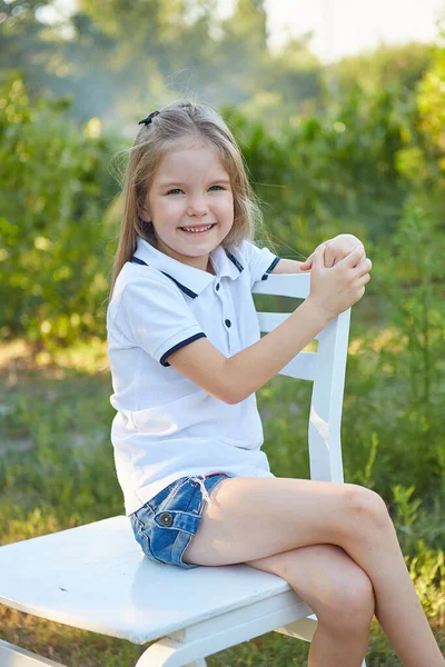 Niña Encantadora Sentada Una Silla Blanca Jardín Verano —  Fotos de Stock