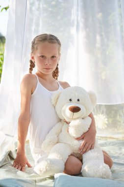 Oyuncak beyaz şifonlu çadırda küçük bir kız. Çocukluk, şefkat, güzellik.