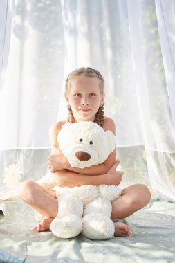 Oyuncak beyaz şifonlu çadırda küçük bir kız. Çocukluk, şefkat, güzellik.