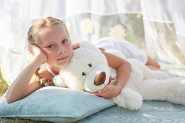 Oyuncak beyaz şifonlu çadırda küçük bir kız. Çocukluk, şefkat, güzellik.