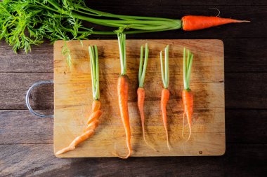 Ahşap arka planda izole bebek havuç Demet