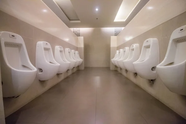 Rij witte urinoirs in mannen badkamer toilet — Stockfoto