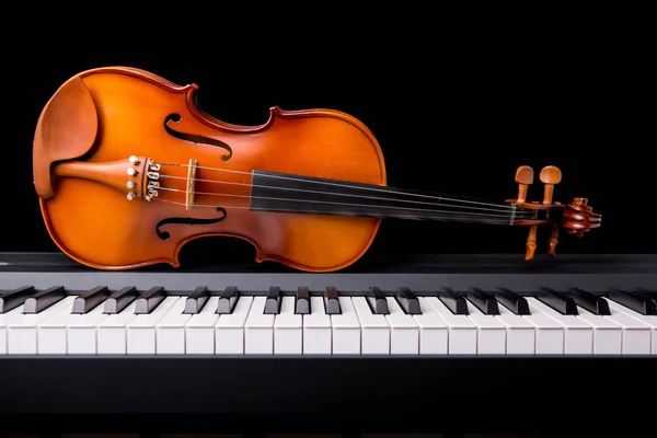 Violino no piano em um fundo preto — Fotografia de Stock