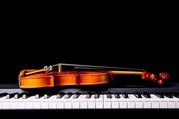 Violino no piano em um fundo preto — Fotografia de Stock