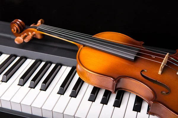 Violino no piano em um fundo preto — Fotografia de Stock