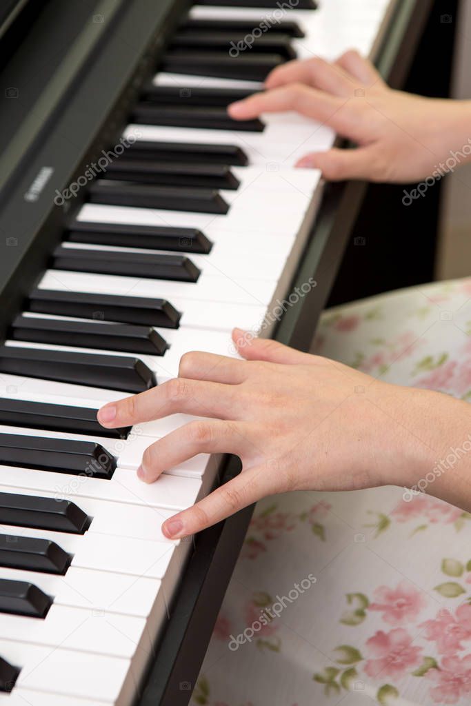 the woman  hands playing piano