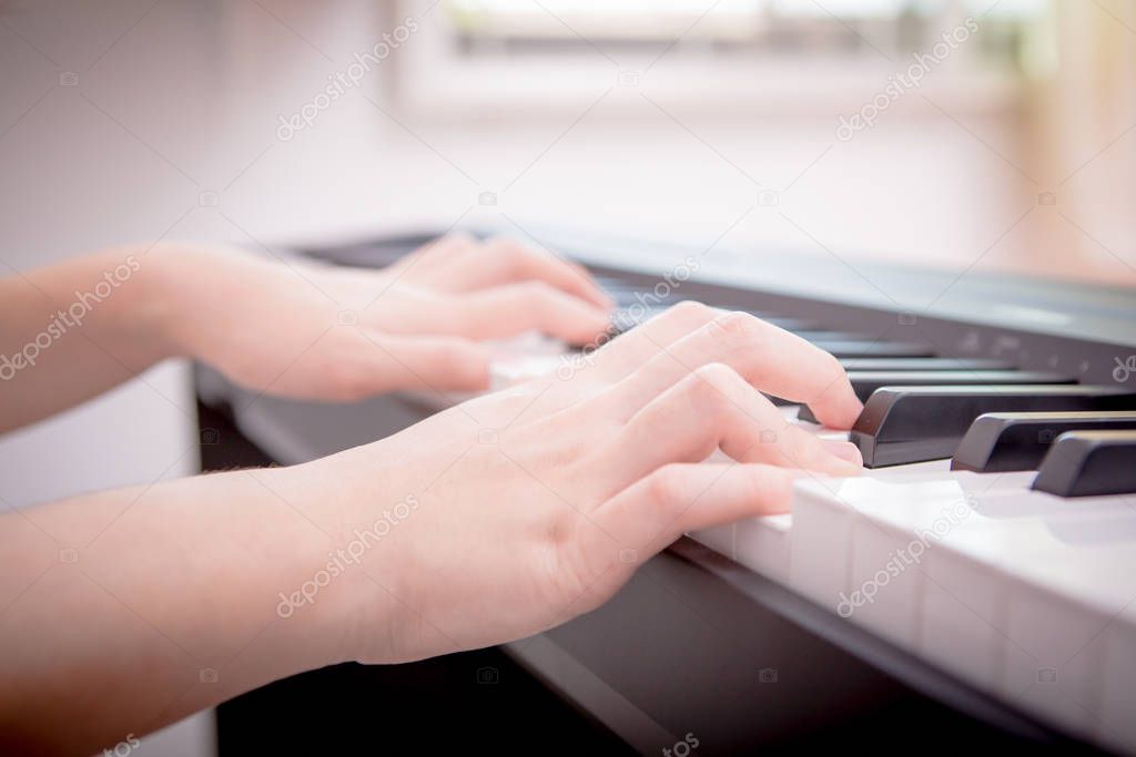 the woman  hands playing piano