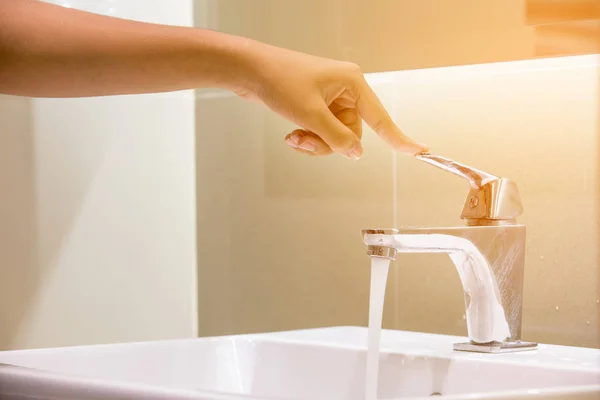 The hand is close the faucet in the bathroom. — Stock Photo, Image