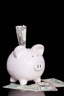 siyah arka plan üzerinde beyaz kumbara içine banka notları