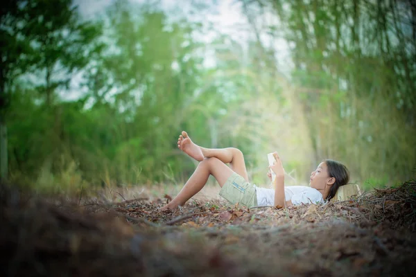 Children reading book in the garden — Stock Photo, Image