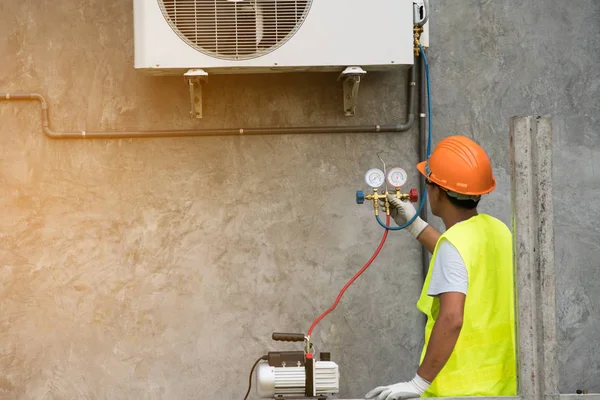 asian man runs the air-conditioning refrigerant from the tank