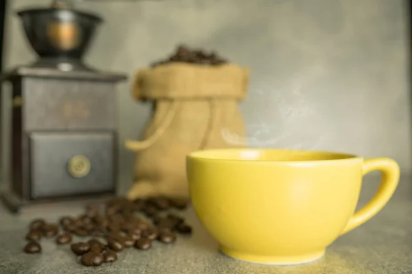 Grãos de café no saco e xícara de café amarelo — Fotografia de Stock