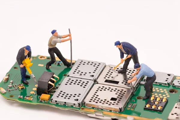 Miniature people repair electronic device — Stock Photo, Image