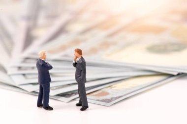 Dolar banknot backgro ile işadamının minyatür heykelcikler