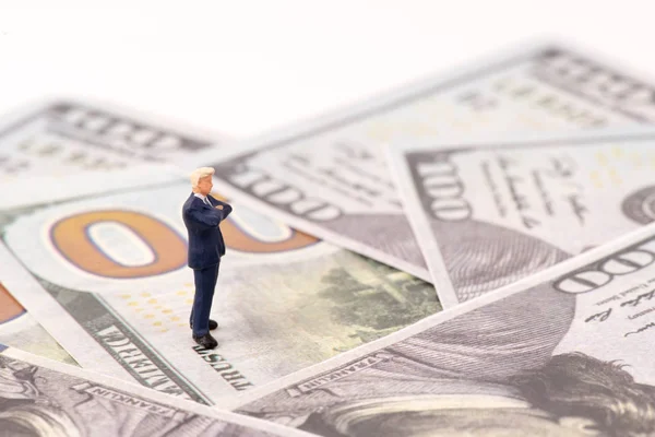 Miniaturní figurky obchodníka s backgro dolarových bankovek — Stock fotografie