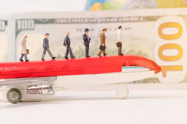 Miniaturní figurky cestovatelů s Orbem, letadlem a dolarem — Stock fotografie