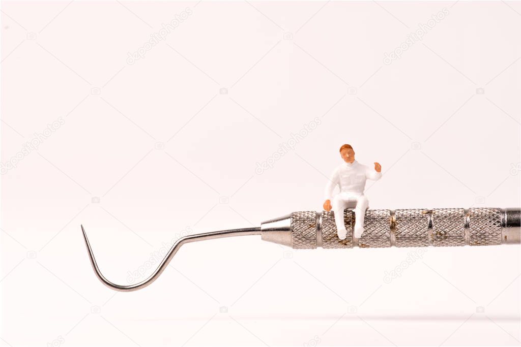 miniature figure people with dental tool on white background