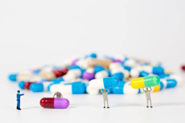 beyaz, tıbbi kavram üzerinde ilaç veya pils üzerinde minyatür insanlar