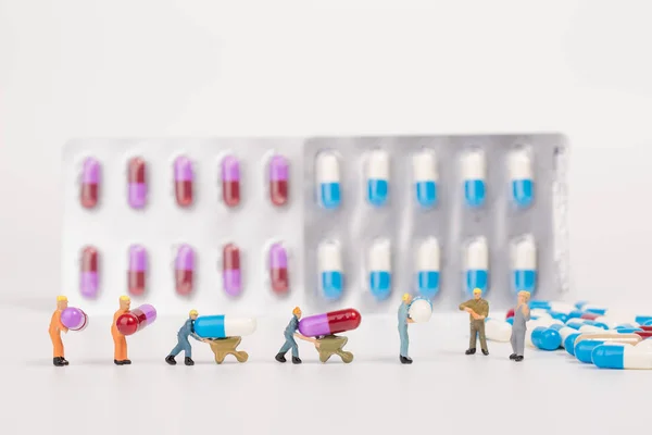 Cápsula de drogas médicas y personas en miniatura sobre fondo blanco, me — Foto de Stock