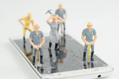 Tamirde minyatür figür işçisi adam ile elektronik tahta ve 