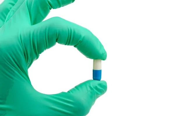Ręka trzyma antybiotyk kapsułka narkotyków na białym tle — Zdjęcie stockowe