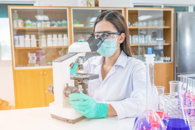 Laboratuvar da mikroskop la çalışan doktor kadın veya kimyager r