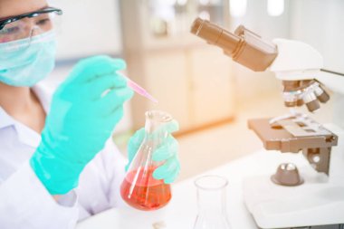 Doktor kadın veya kimyager damlalık damla sıvı kimyasal kullanın 