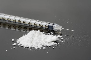 siyah cam üzerinde şırınga ve kahraman tozu