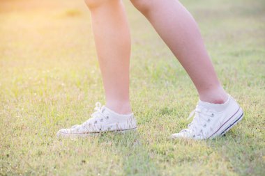 kadınlar spor ayakkabı ile çim üzerinde yürümek