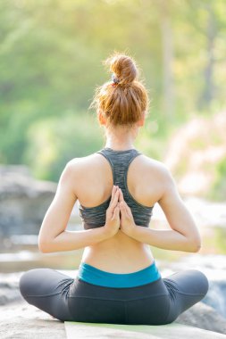 Asyalı genç kadın şelale yakınında yoga pratik