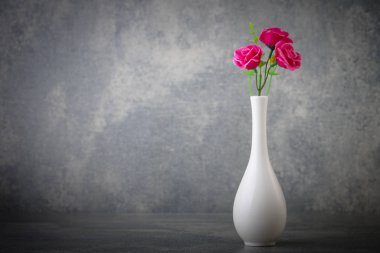 beton arka plan ile beyaz vaset yapay çiçekler