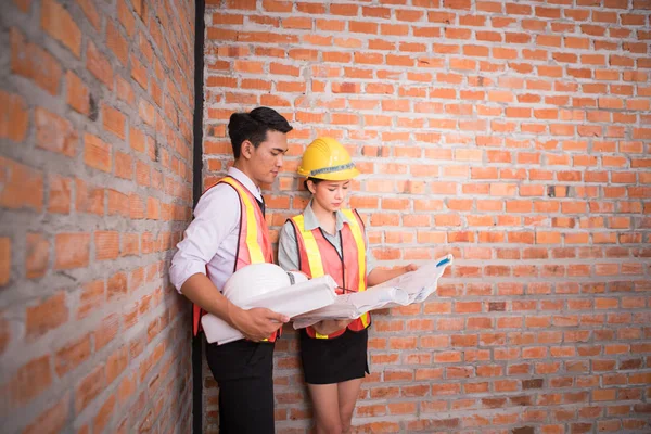 kadın ve adam construc eski tuğla duvar arka plan ile çalışan