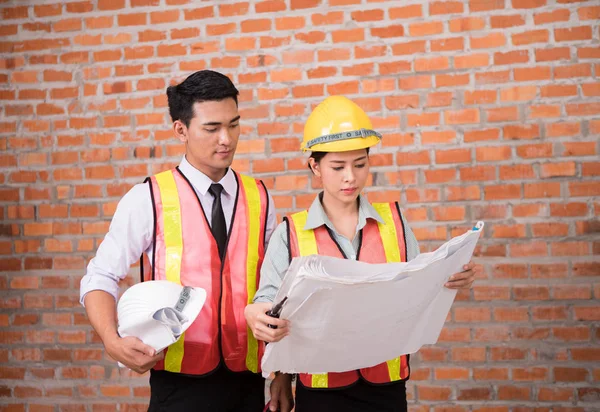 kadın ve adam construc eski tuğla duvar arka plan ile çalışan