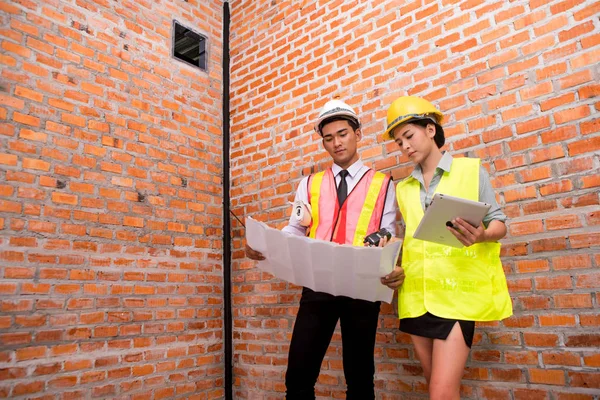 kadın ve adam construc eski tuğla duvar arka plan ile çalışan