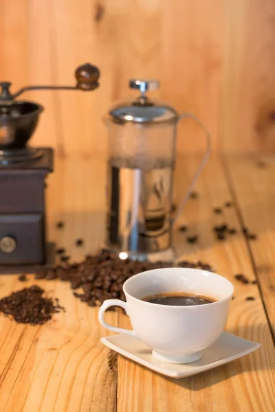 Xícara de café e grãos de café na mesa de madeira — Fotografia de Stock