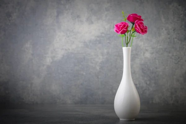 Artificial flowers in white vaset with background of concrete — Stock Photo, Image
